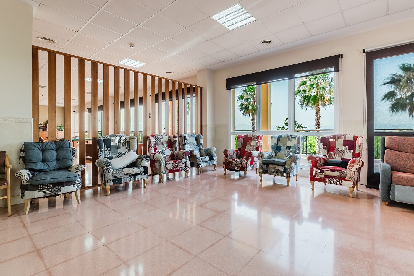 Sala de estar luminosa con butacas y zonas de convivencia